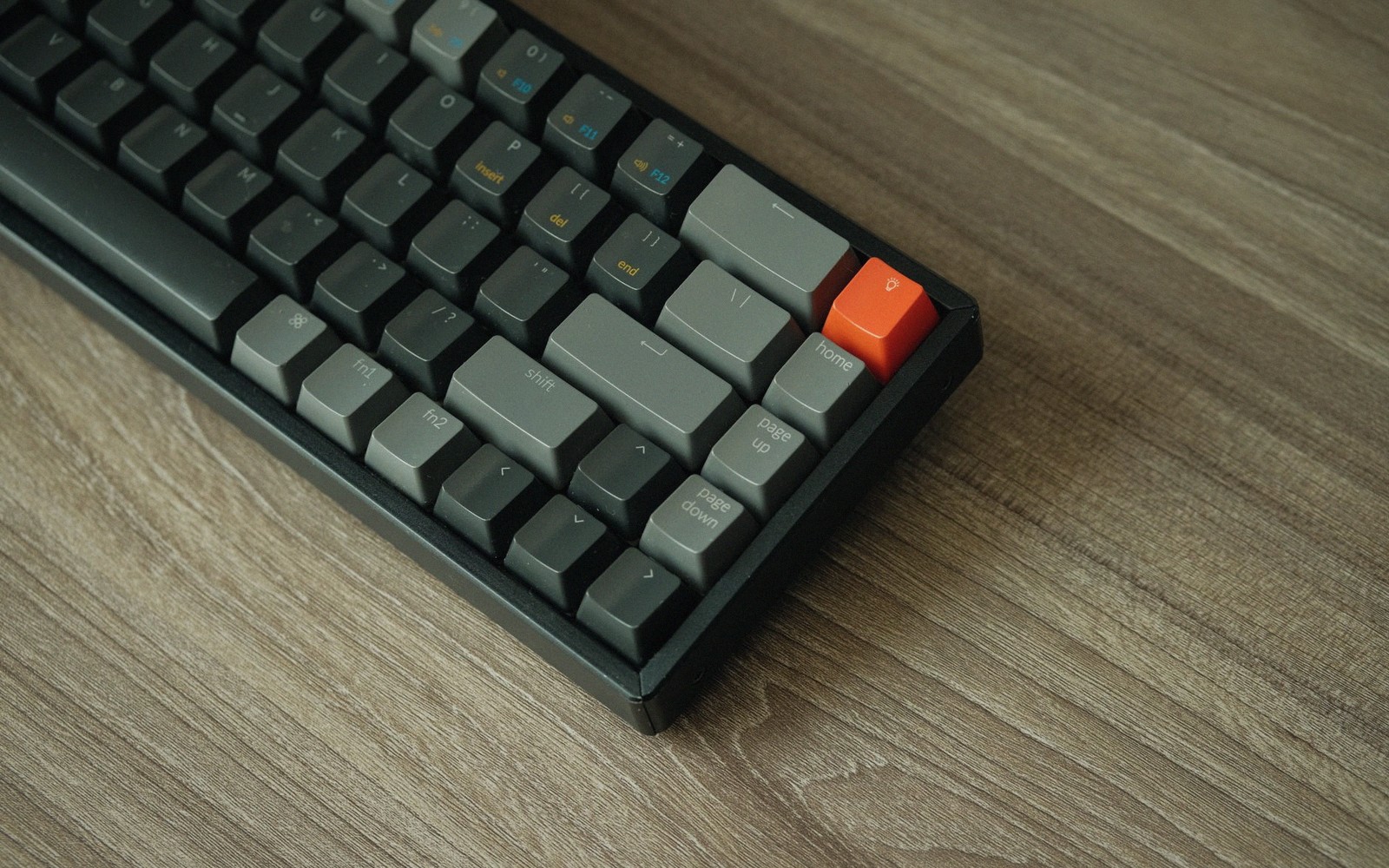 a mechanical keyboard on a wooden desk in low light
